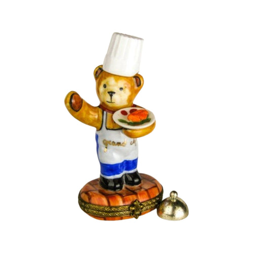 Plush teddy bear dressed in chef's outfit, holding a cooking utensil