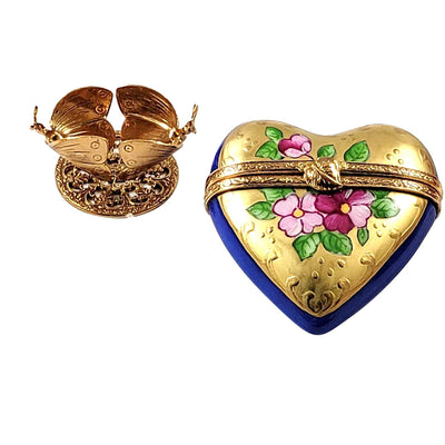 Detailed brass butterfly stand holding a gorgeous blue-gold heart-shaped glass