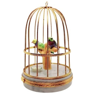 Ornate Limoges figurine box featuring lifelike tanager birds in a cage illustration