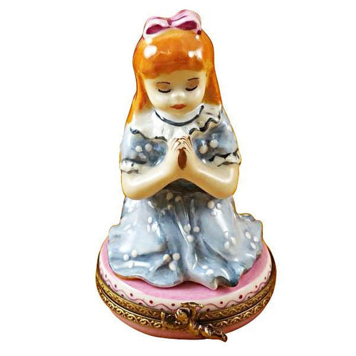 Red-haired girl with closed eyes holding hands together in prayer 