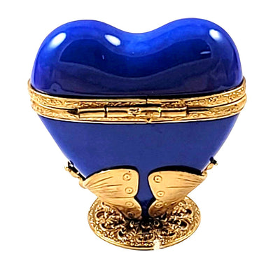 Ornate brass butterfly stand supporting a stunning blue-gold heart-shaped glass