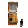 A wooden crate filled with bottles of Bordeaux wine, a glass, and a corkscrew