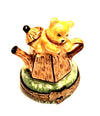 A charming vintage-style teddy bear nestled inside a delicate teapot, evoking the charm of China and France
